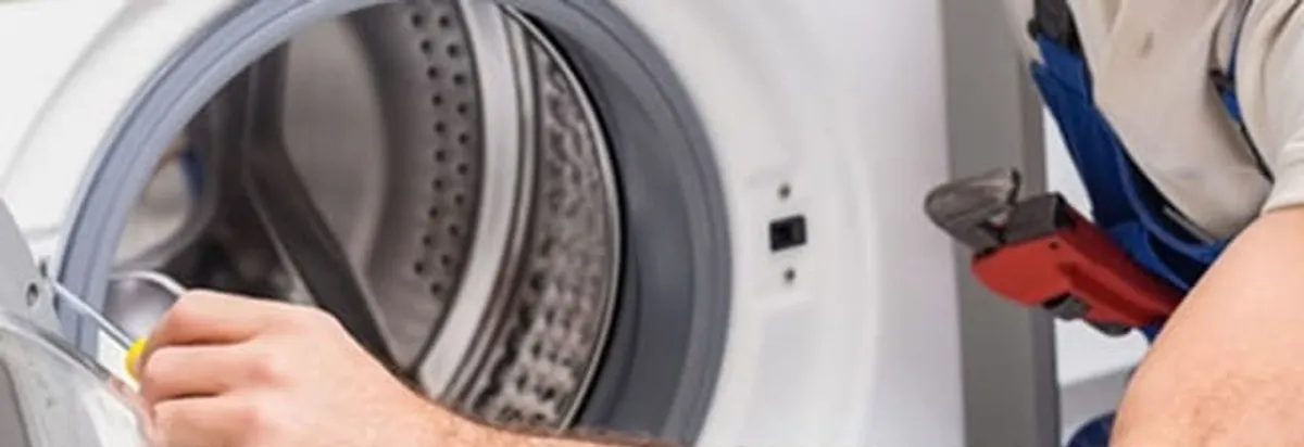 Appliance technician repairing a clothes dryer drum and internal parts in Columbus, OH