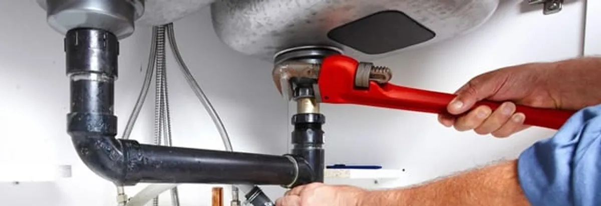 Garbage disposal repair technician tightening the sink drain and disposal connection in Columbus, OH