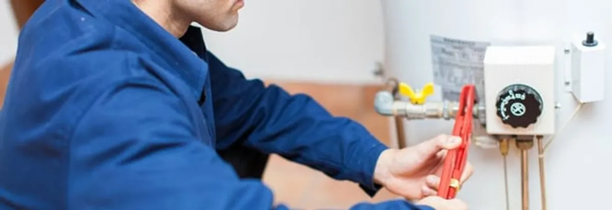 Water heater repair technician adjusting the temperature control and gas valve in Columbus, OH